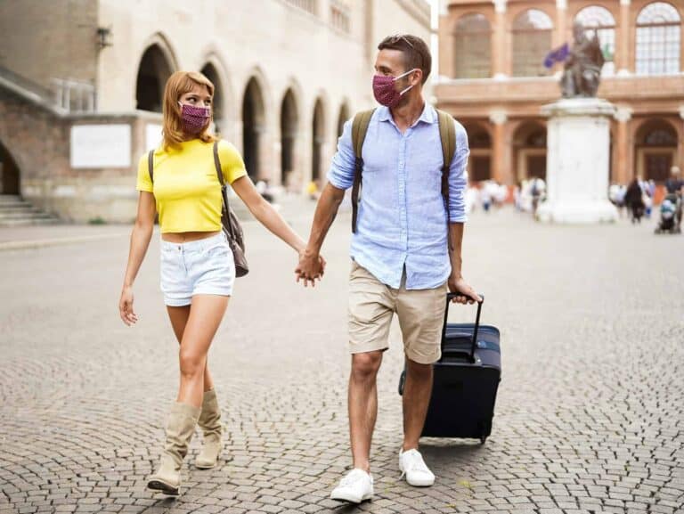 Couple of tourist wearing face mask to protect from Covid19 are walking in the city