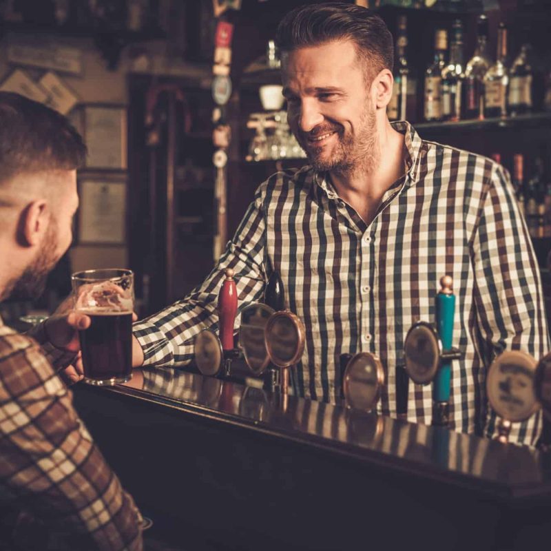 Man chatting with a bartender in a pub