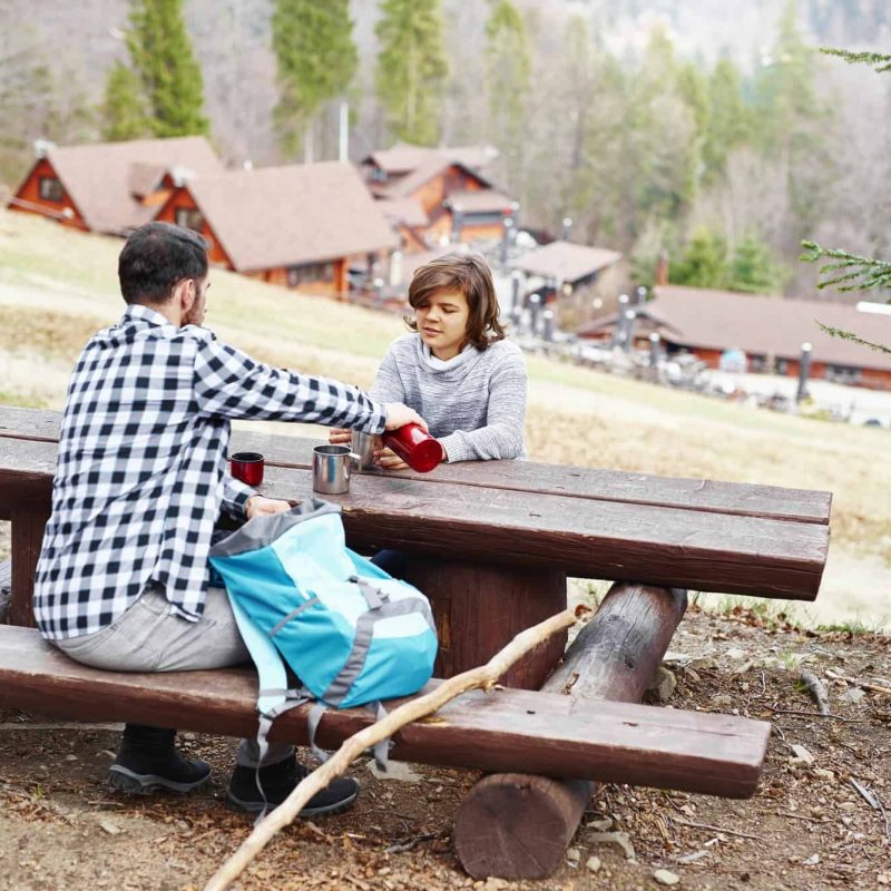 rear-view-of-hiker-pouring-his-son-some-hot-tea.jpg